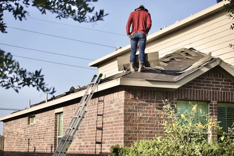 Professional roofer working on a residential roof in Evansdale